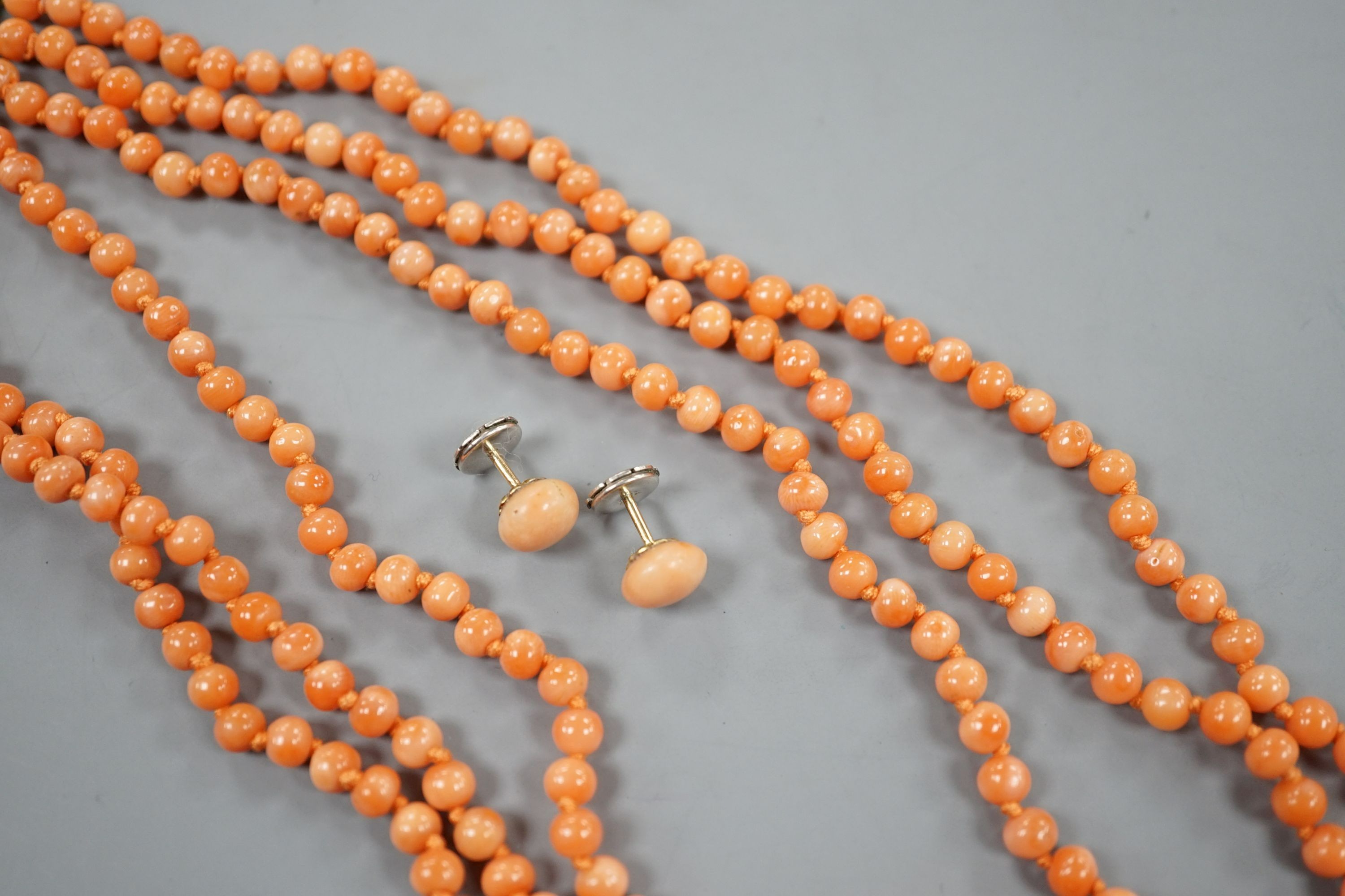 A triple strand coral bead necklace, 46cm and a pair of coral bead earrings.